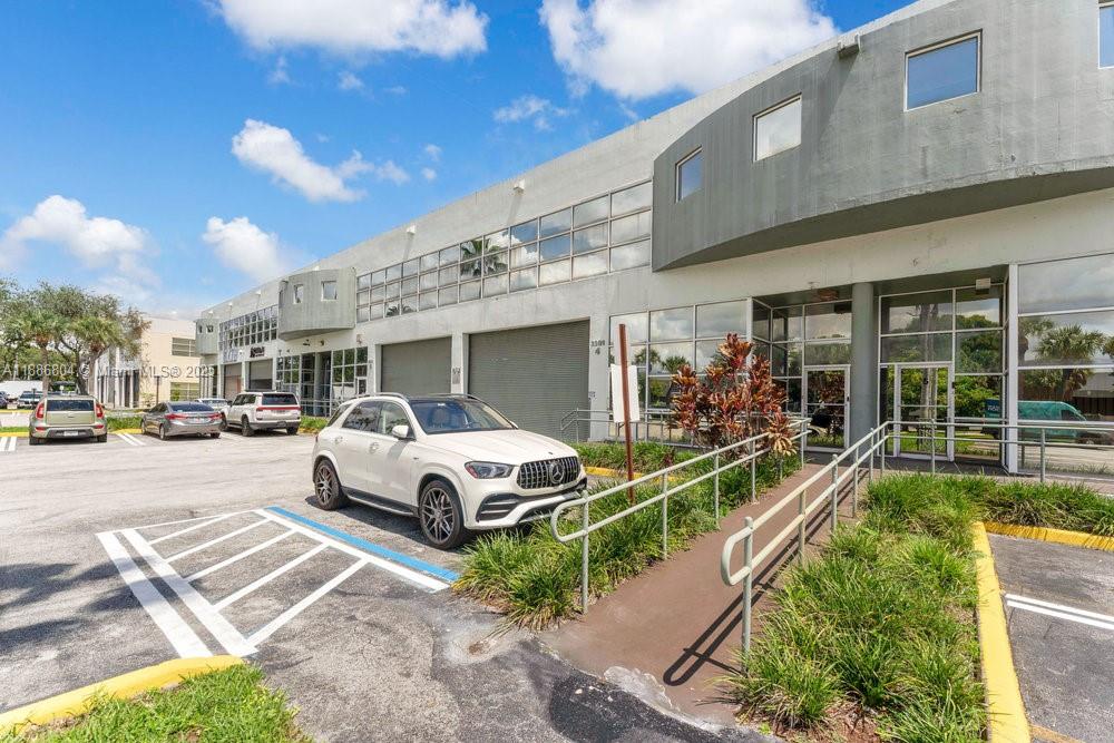 A white SUV is parked in front of a commercial building with glass storefronts — 2201 NW 102nd Pl # 4A, Doral FL 33172, DORAL, FL