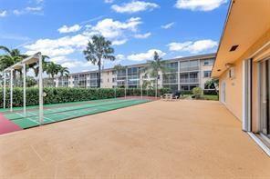 An outdoor shuffleboard court sits on a tan patio next to a multi-story apartment building — 4500 N Federal Highway # 153, Lighthouse Point FL 33064, LIGHTHOUSE POINT, FL