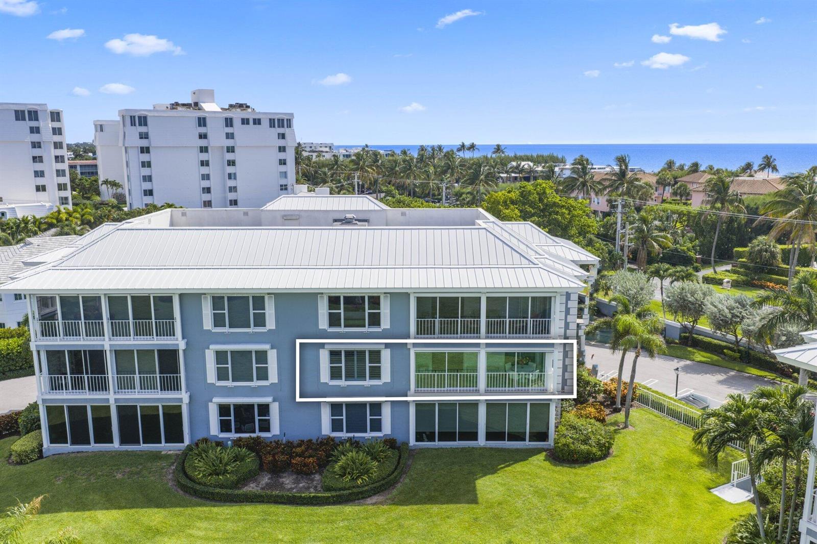 An exterior view of a multi-story blue apartment building with a highlighted second-floor balcony — 2150 S Ocean Boulevard # 3c, Delray Beach FL 33483, DELRAY BEACH, FL