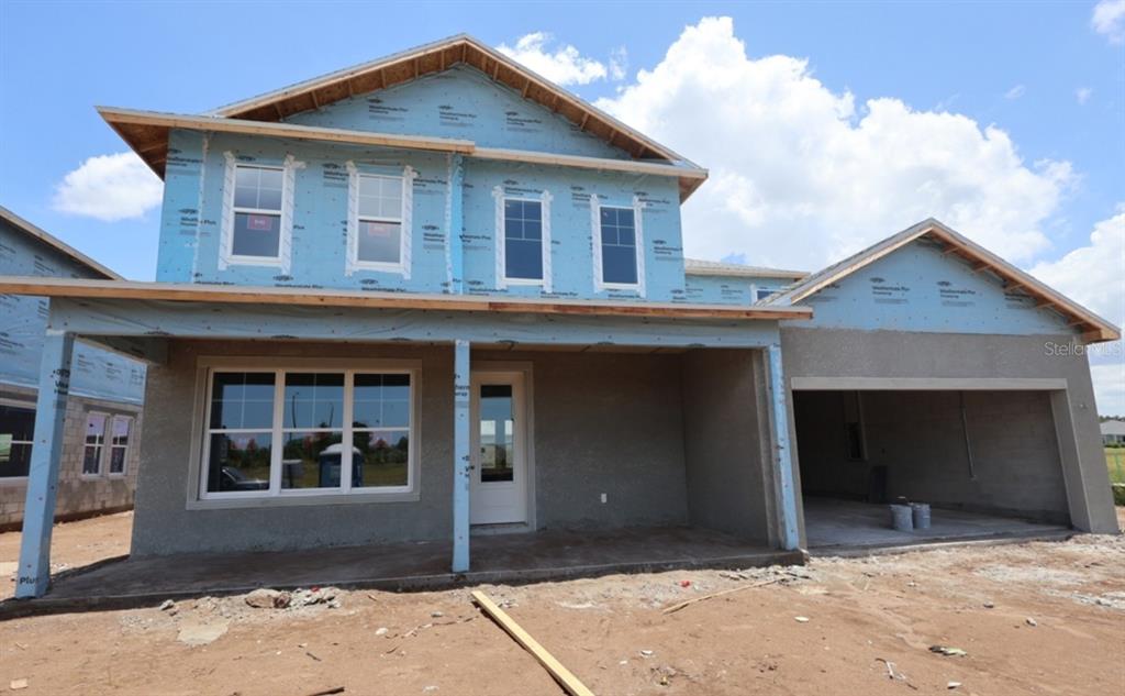 A two-story house under construction with blue weather-resistant sheathing and an unfinished concrete facade — 7709 MARINA BAY COVE, PALMETTO, FL