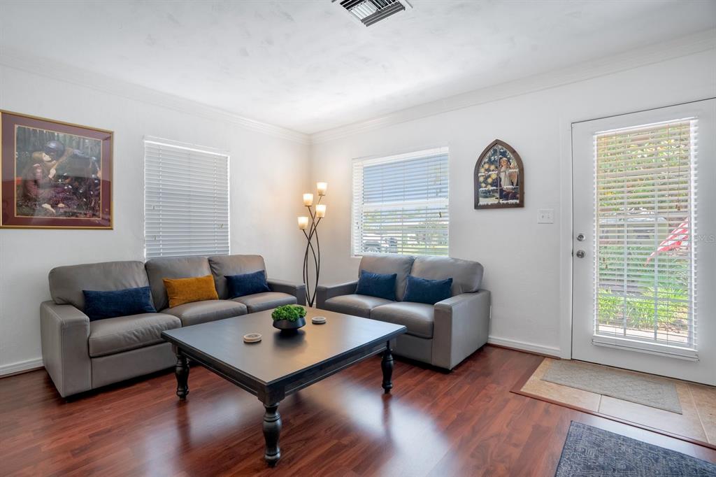 A living room with gray sofas, a dark coffee table, and wood-look flooring — 607 KERNEYWOOD STREET, LAKELAND, FL