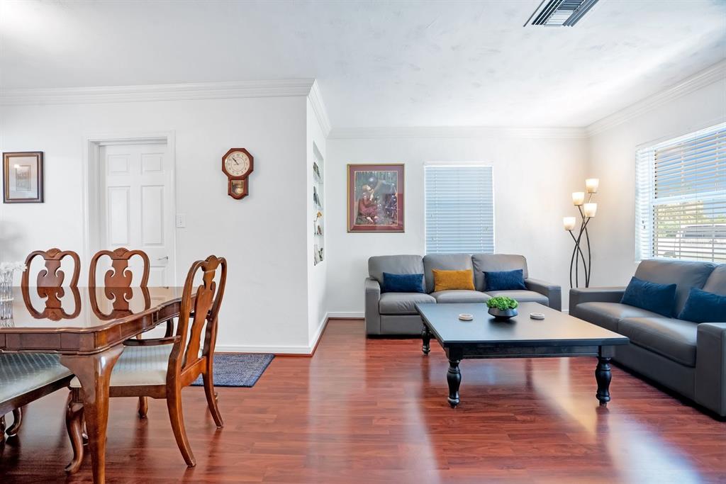 A dining area and living room with hardwood floors, gray sofas, and a coffee table — 607 KERNEYWOOD STREET, LAKELAND, FL