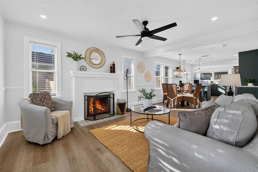 A living room features a fireplace, a ceiling fan, and an open view of the kitchen — 4624 IRIS STREET N, ST PETERSBURG, FL