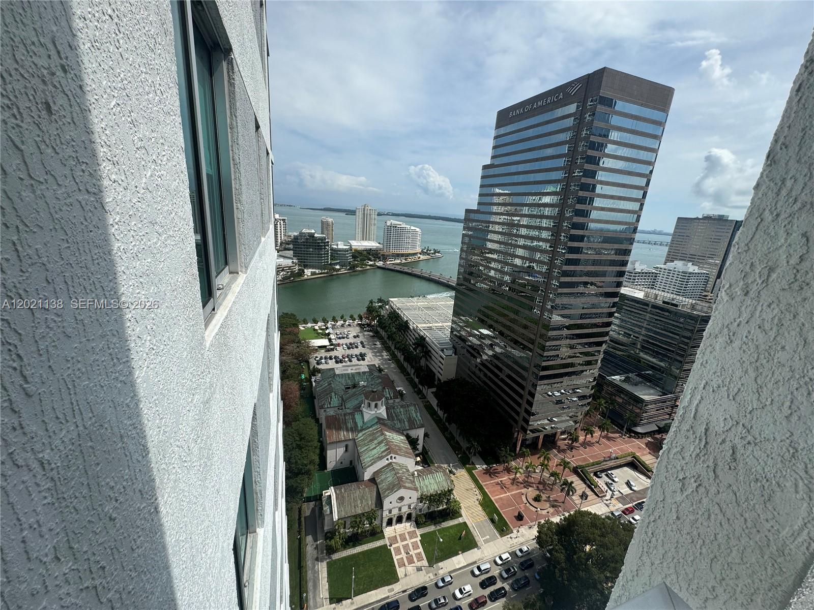 An elevated view shows a city skyline, a bay, and a prominent Bank of America building — 500 Brickell Ave # 3204, Miami FL 33131, MIAMI, FL