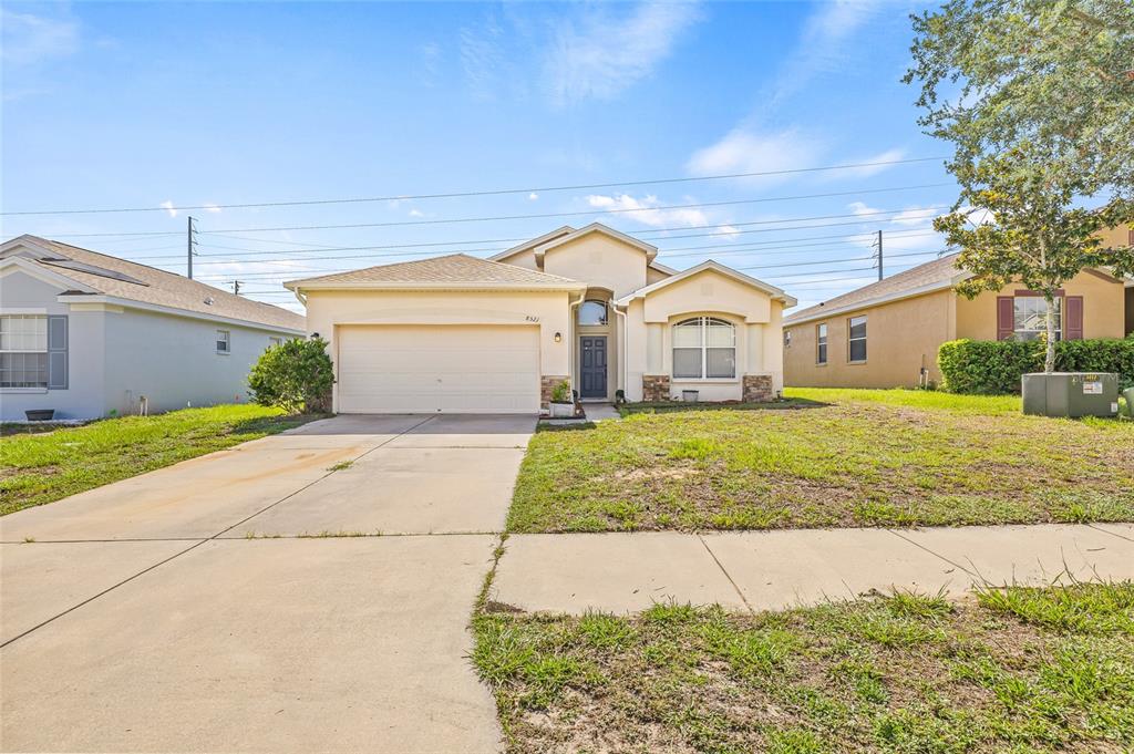 A single-story suburban house with a two-car garage and a concrete driveway — 8521 SOUTHERN CHARM CIRCLE, BROOKSVILLE, FL