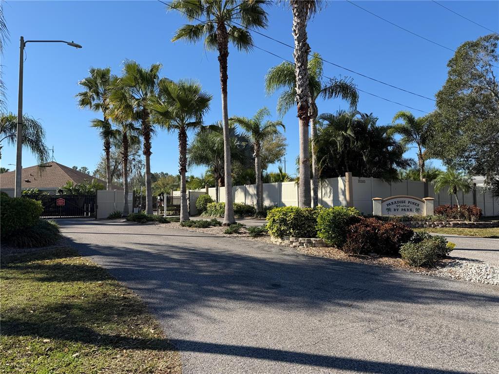 The entrance to a gated RV park features palm trees, landscaping, and a signage monument — 20300 LEONARD ROAD UNIT 78, LUTZ, FL