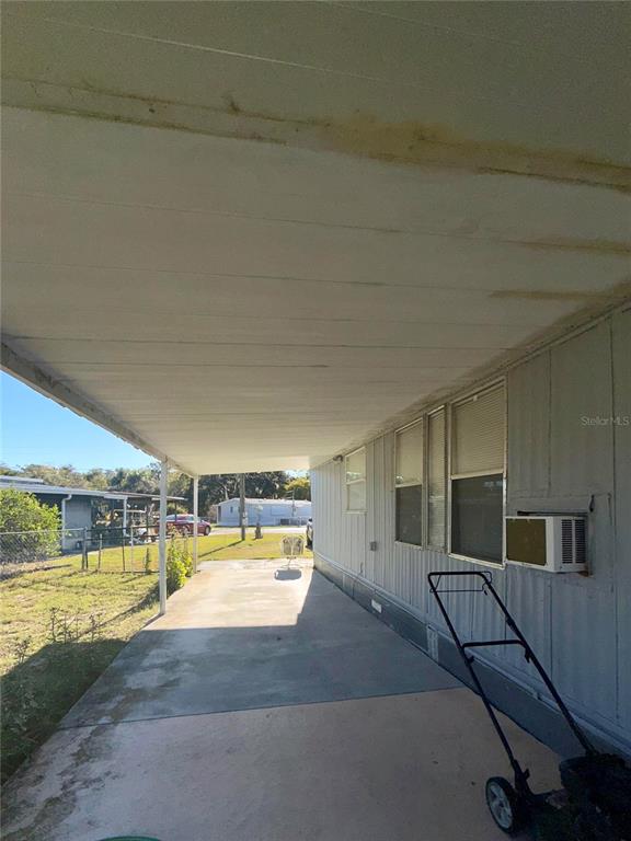 A covered concrete carport extends along the side of a mobile home — 1370 COUNTY DRIVE, TAVARES, FL