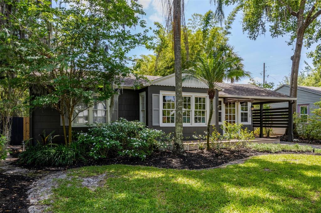 A dark gray single-story house with a front porch, white trim, and lush landscaping — 2020 PALMER STREET, ORLANDO, FL