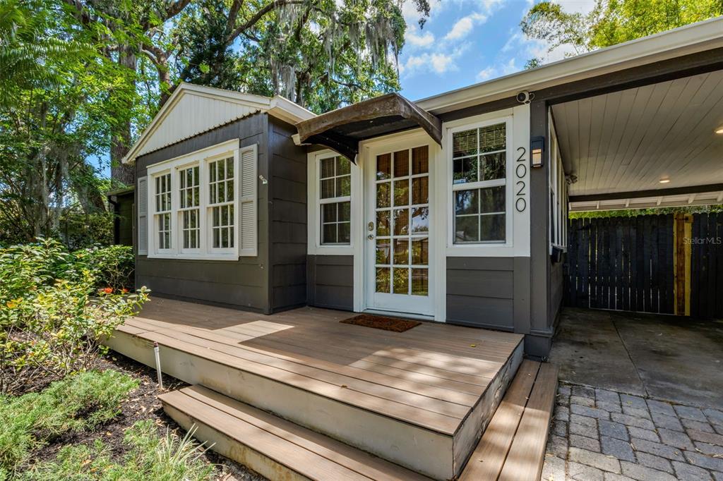 A dark-painted house exterior features a wooden deck, a glass-paned door, and a carport — 2020 PALMER STREET, ORLANDO, FL