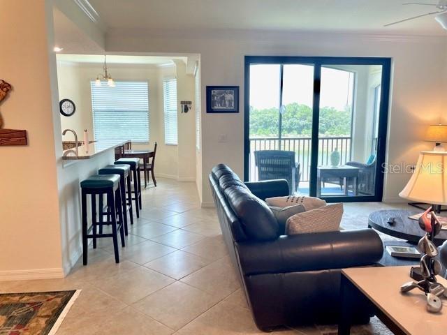 A living room with a black leather sofa overlooks a balcony through sliding glass doors — 16814 VARDON TERRACE UNIT 307, BRADENTON, FL