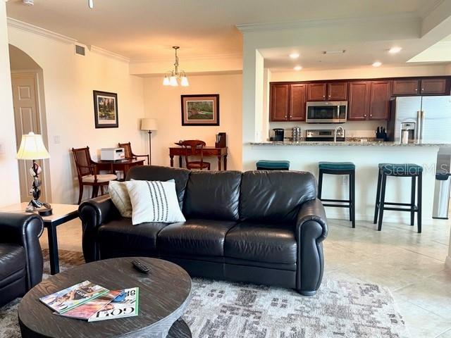 A living room with a leather sofa opens to a kitchen with dark wood cabinets — 16814 VARDON TERRACE UNIT 307, BRADENTON, FL