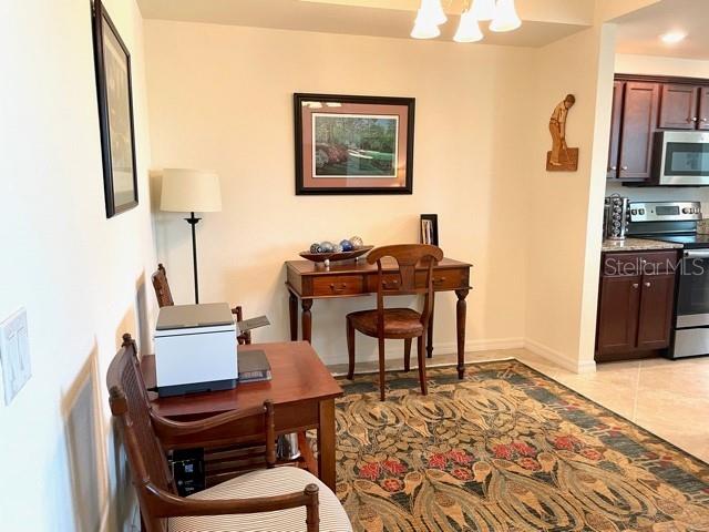 A dining area features a wooden desk, a chair, a printer, and a patterned rug — 16814 VARDON TERRACE UNIT 307, BRADENTON, FL