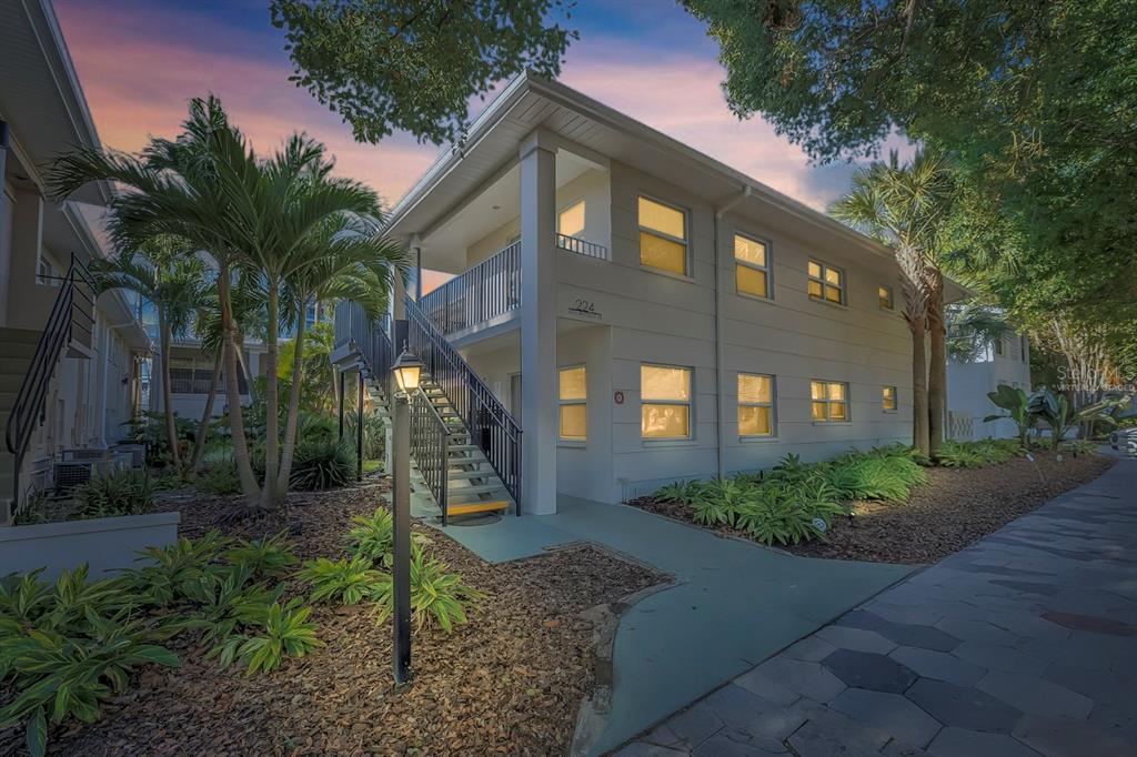A two-story apartment building exterior features a staircase leading to an upper-level balcony — 224 6TH AVENUE N UNIT 7, ST PETERSBURG, FL