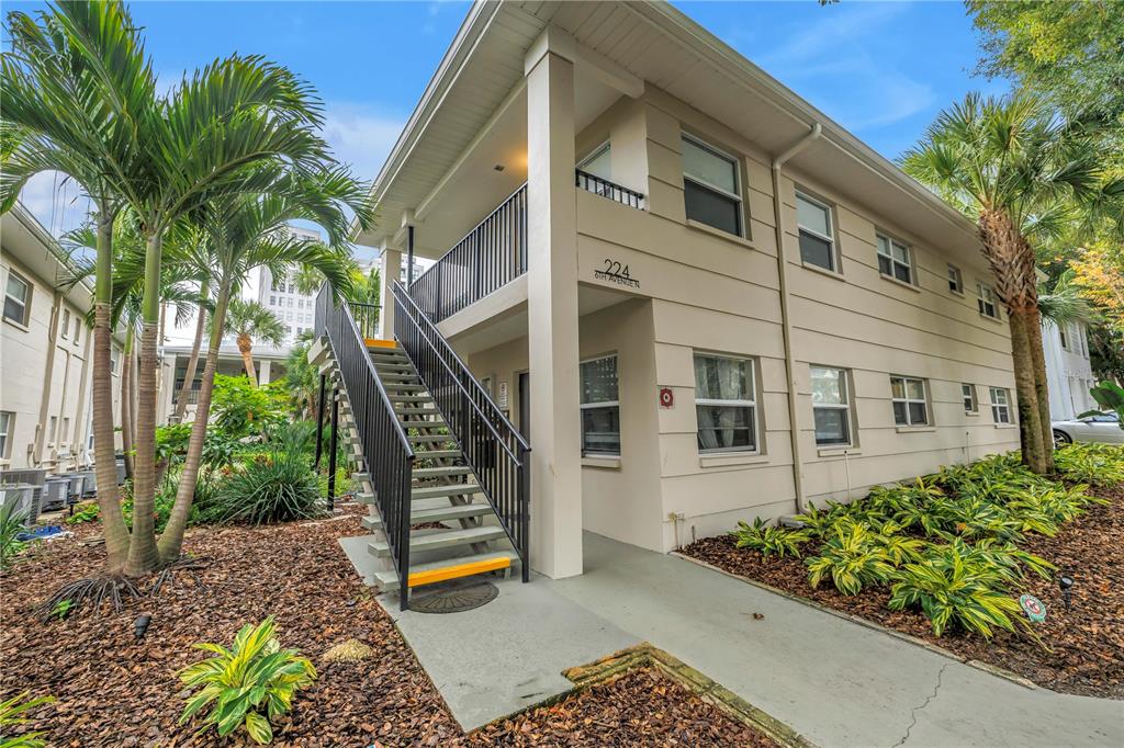 A two-story apartment building exterior features a metal staircase leading to an upper balcony — 224 6TH AVENUE N UNIT 7, ST PETERSBURG, FL