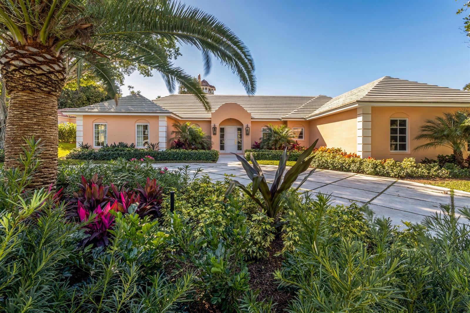 A peach-colored house with a tiled roof and a palm tree in the front yard — 124 Woodbridge Road, Palm Beach FL 33480, PALM BEACH, FL