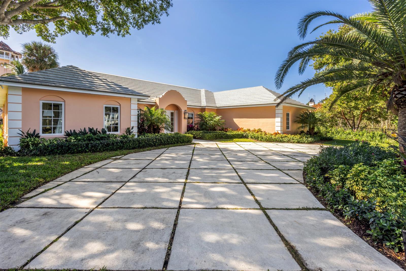 A peach-colored house with a tiled roof features a large grid-patterned concrete driveway — 124 Woodbridge Road, Palm Beach FL 33480, PALM BEACH, FL