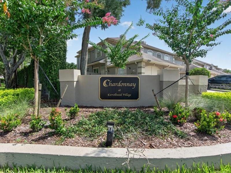 A sign for Chardonnay at Carrollwood Village stands in front of a multi-story residential building — 14012 NOTREVILLE WAY, TAMPA, FL