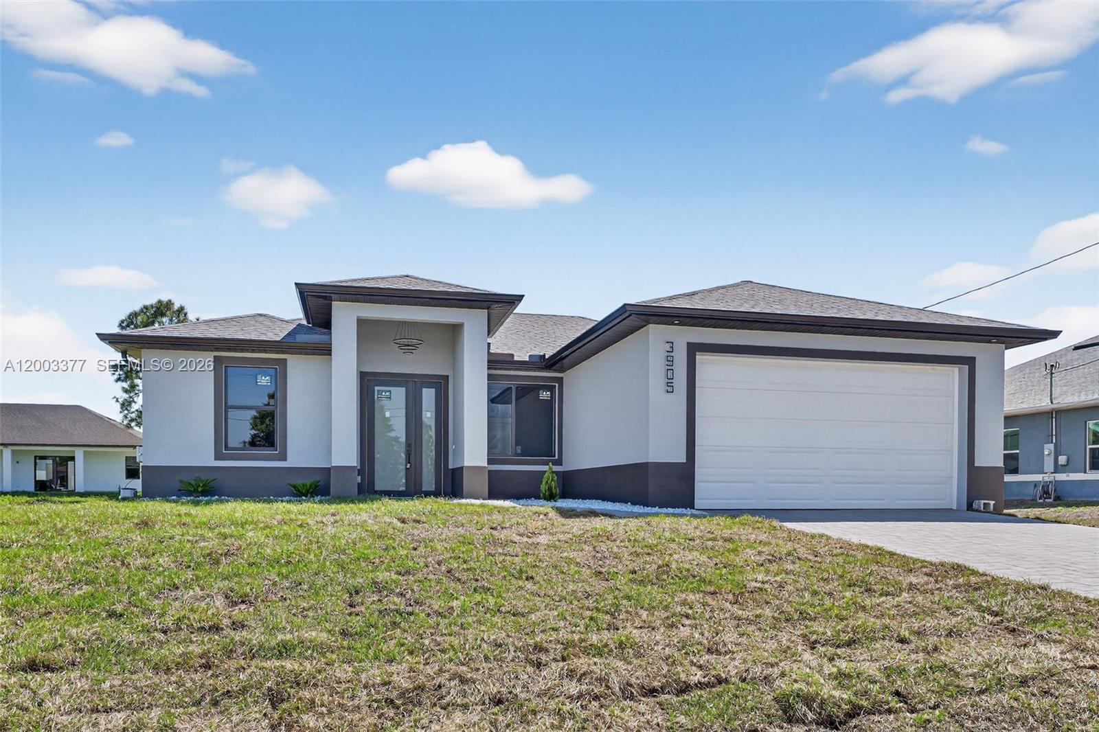 A modern single-story house features a two-tone exterior, a front entrance, and an attached garage — 3903 SW 11, Lehigh Acres FL 33976, LEHIGH ACRES, FL