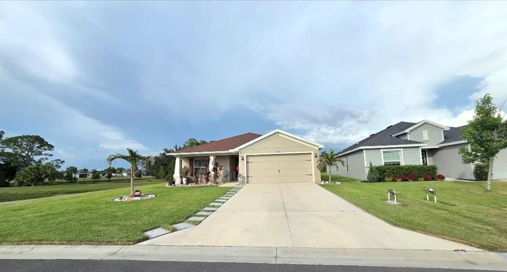 A single-story house with a beige exterior, a two-car garage, and a concrete driveway — 6324 165TH DRIVE E, PARRISH, FL