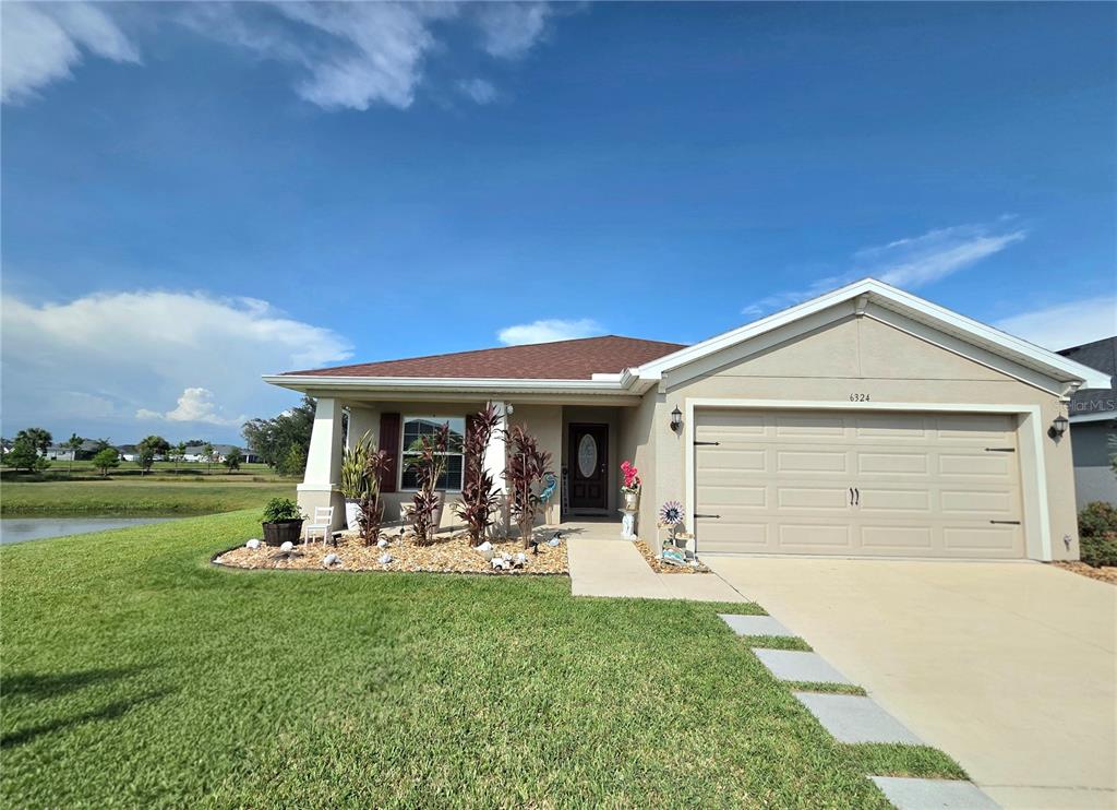 A single-story house with a beige exterior, a two-car garage, and a concrete driveway — 6324 165TH DRIVE E, PARRISH, FL