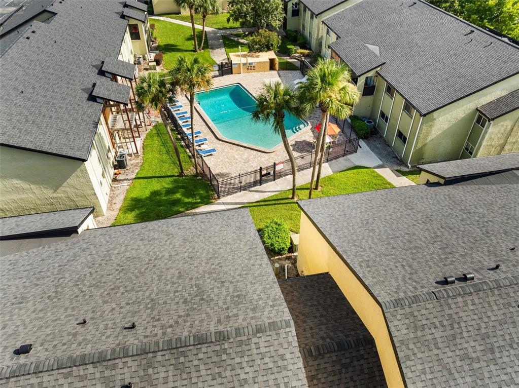An aerial view shows a swimming pool surrounded by a patio and apartment buildings — 910 LAKE DESTINY ROAD UNIT B, ALTAMONTE SPRINGS, FL