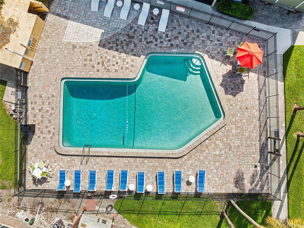 An aerial view shows an L-shaped swimming pool surrounded by a paved deck and fence — 910 LAKE DESTINY ROAD UNIT B, ALTAMONTE SPRINGS, FL