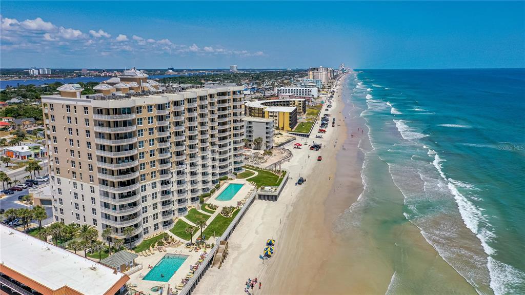 An aerial view shows a large beachfront condominium complex with two swimming pools — 2403 S ATLANTIC AVENUE UNIT 309, DAYTONA BEACH, FL