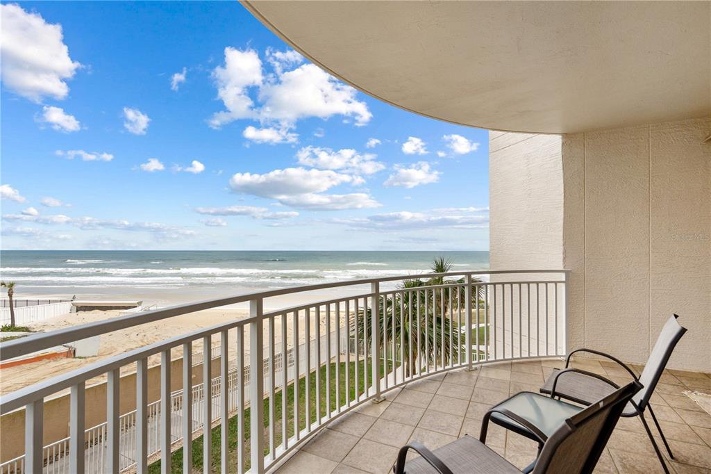 A tiled balcony overlooks the ocean with a white railing and two patio chairs — 2403 S ATLANTIC AVENUE UNIT 309, DAYTONA BEACH, FL