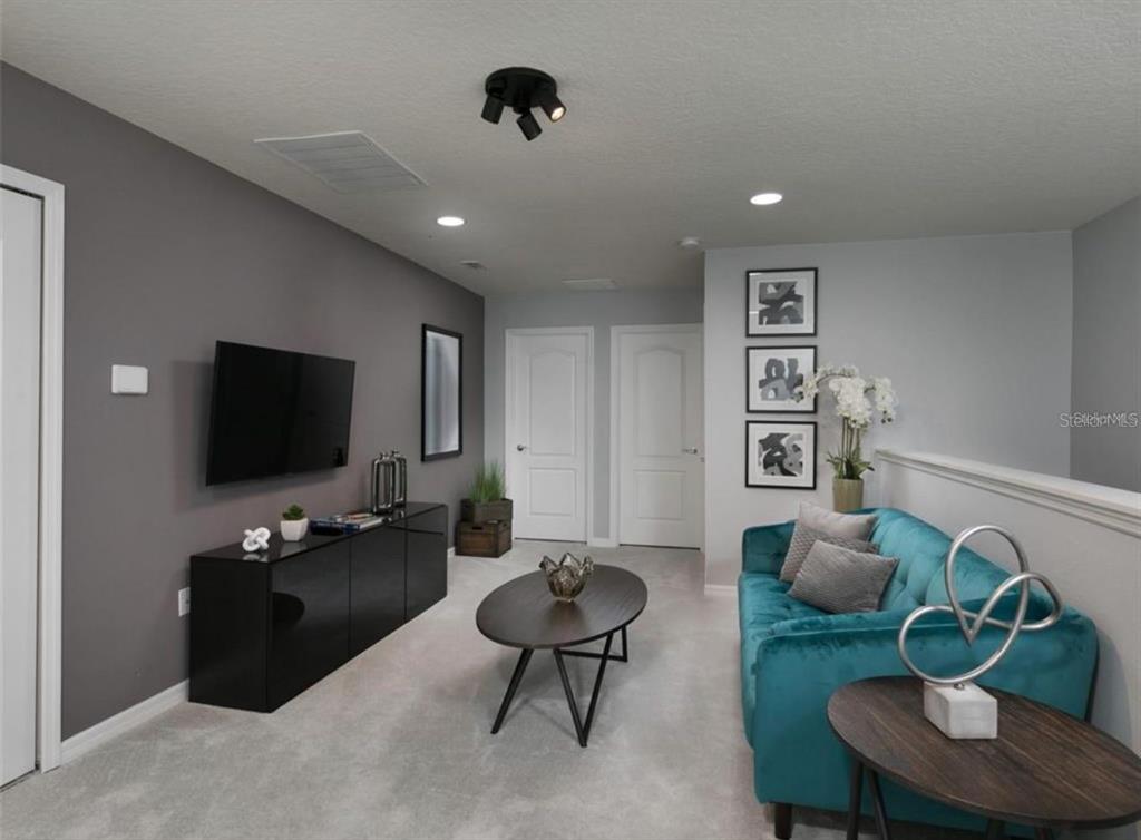 A living room features a teal sofa, a black media console, and a coffee table — 8831 GENEVE COURT, KISSIMMEE, FL