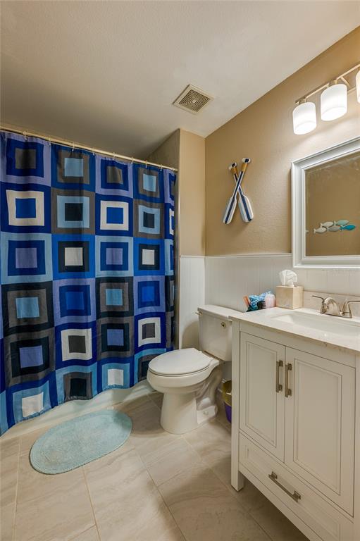 A bathroom features a blue geometric shower curtain, a white vanity, and a toilet — 11 ZIRCON COURT, PALM COAST, FL