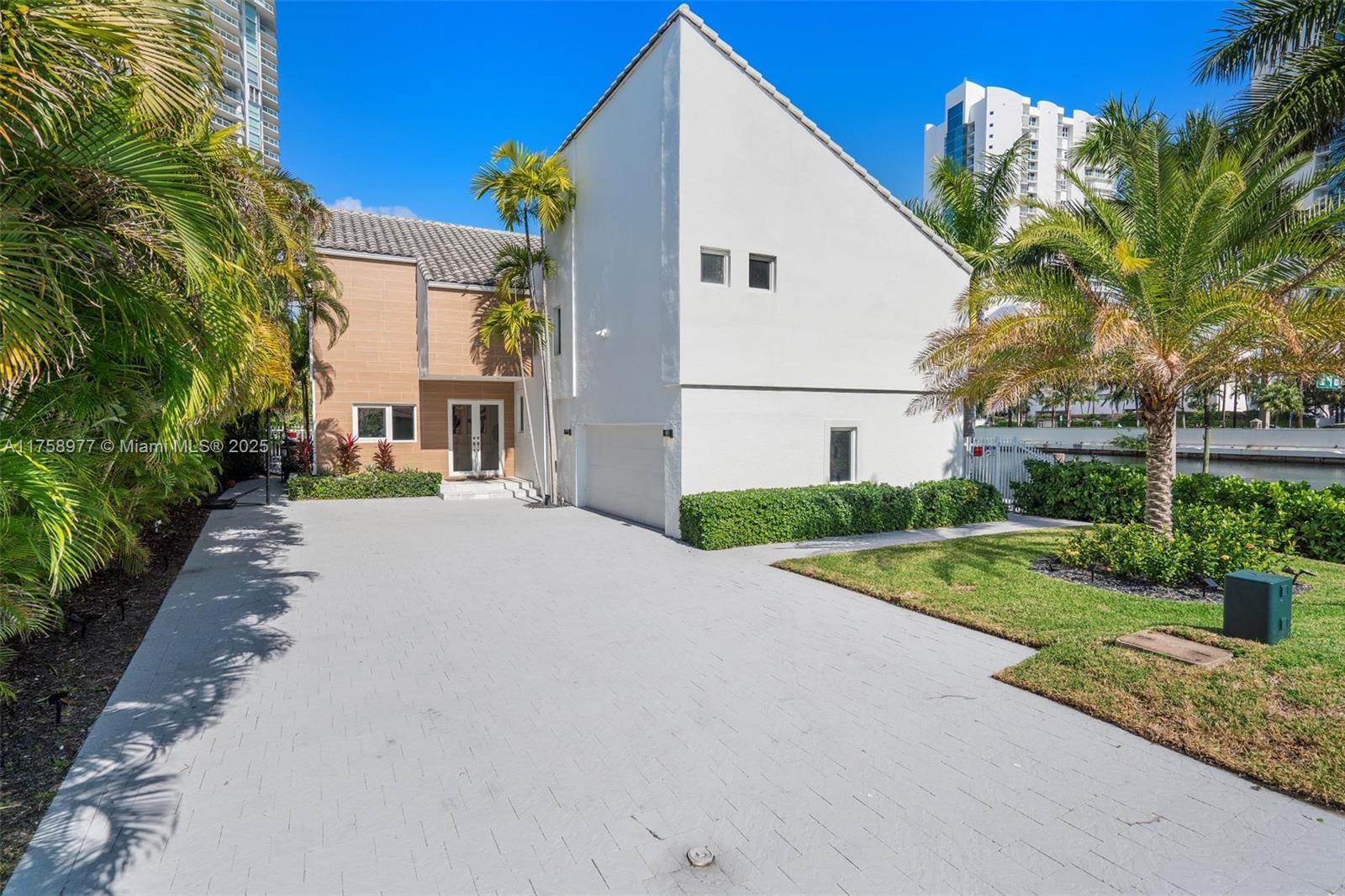 A two-story house with a white facade, a paved driveway, and palm trees — 201 Atlantic Ave, Sunny Isles Beach FL 33160, SUNNY ISLES BEACH, FL