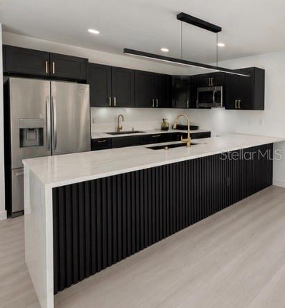 A modern kitchen features black cabinetry, a large white waterfall island, and stainless steel appliances — 3010 6TH AVENUE S, ST PETERSBURG, FL
