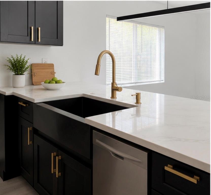 A kitchen features black cabinets, a white countertop, a farmhouse sink, and gold hardware — 3010 6TH AVENUE S, ST PETERSBURG, FL