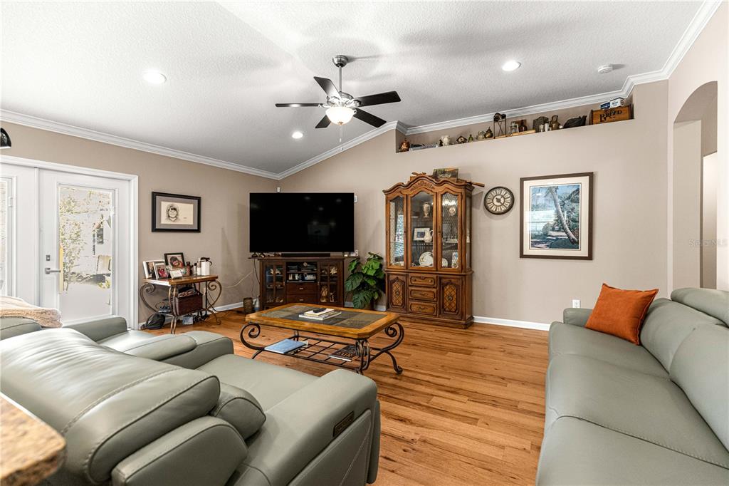 A living room features light gray leather sofas, a wooden hutch, and a television console — 4328 CHOKEBERRY, MIDDLEBURG, FL