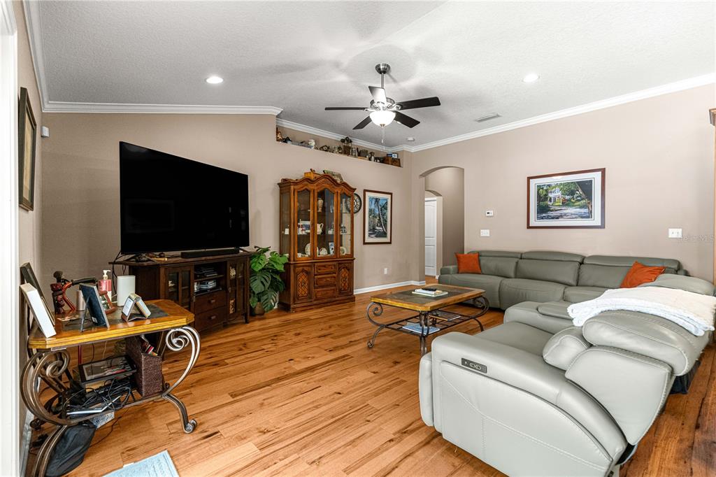 A living room features hardwood floors, a large television, and a light gray sectional sofa — 4328 CHOKEBERRY, MIDDLEBURG, FL