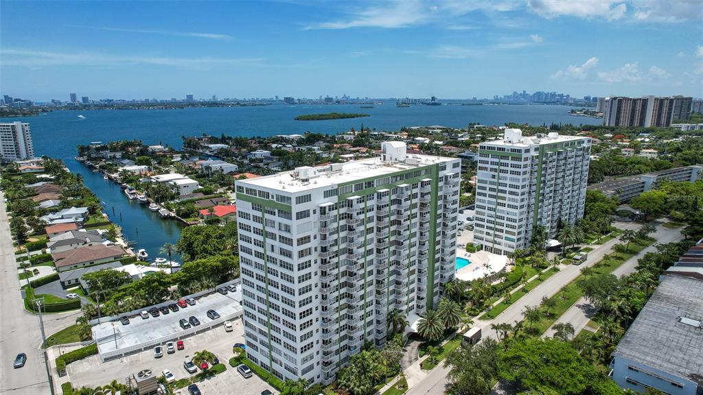 An aerial view shows two tall residential buildings near a bay with boats — 2150 SANS SOUCI BOULEVARD UNIT #C402, NORTH MIAMI, FL