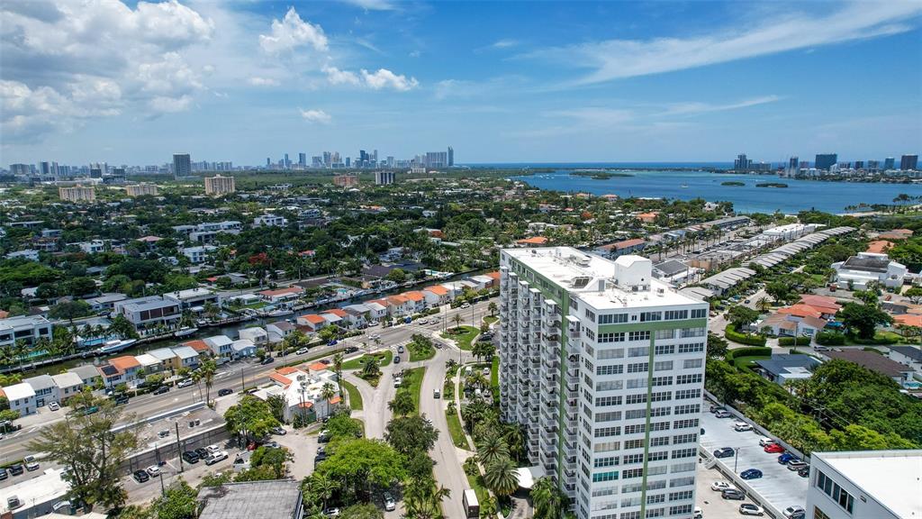 An aerial view shows a tall residential building surrounded by suburban homes and waterways — 2150 SANS SOUCI BOULEVARD UNIT #C402, NORTH MIAMI, FL