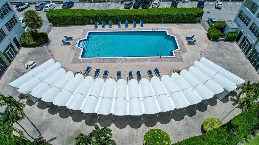 An aerial view of a swimming pool surrounded by lounge chairs and a curved canopy — 2150 SANS SOUCI BOULEVARD UNIT #C402, NORTH MIAMI, FL