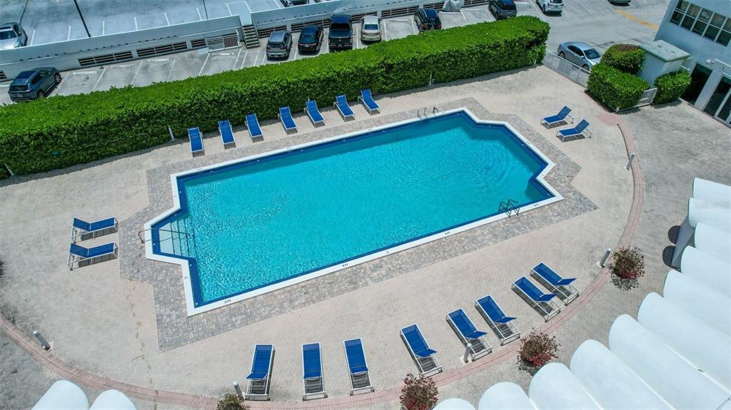 An aerial view shows a rectangular swimming pool surrounded by lounge chairs and landscaping — 2150 SANS SOUCI BOULEVARD UNIT #C402, NORTH MIAMI, FL