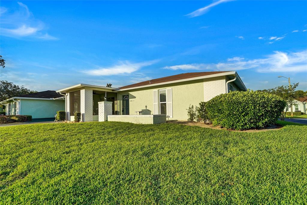 A light green single-story house with a white brick entryway and a large front lawn — 11340 DOLLAR LAKE DRIVE UNIT 2, PORT RICHEY, FL