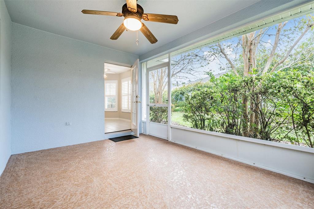 A sunroom with a ceiling fan, textured flooring, and a screen door leading outdoors — 10230 OLD TAMPA BAY DRIVE, SAN ANTONIO, FL