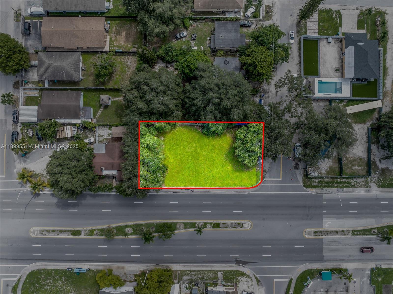 An aerial view shows a vacant, rectangular grass lot bordered by a multi-lane road — 90 2200, Miami FL 33147, MIAMI, FL