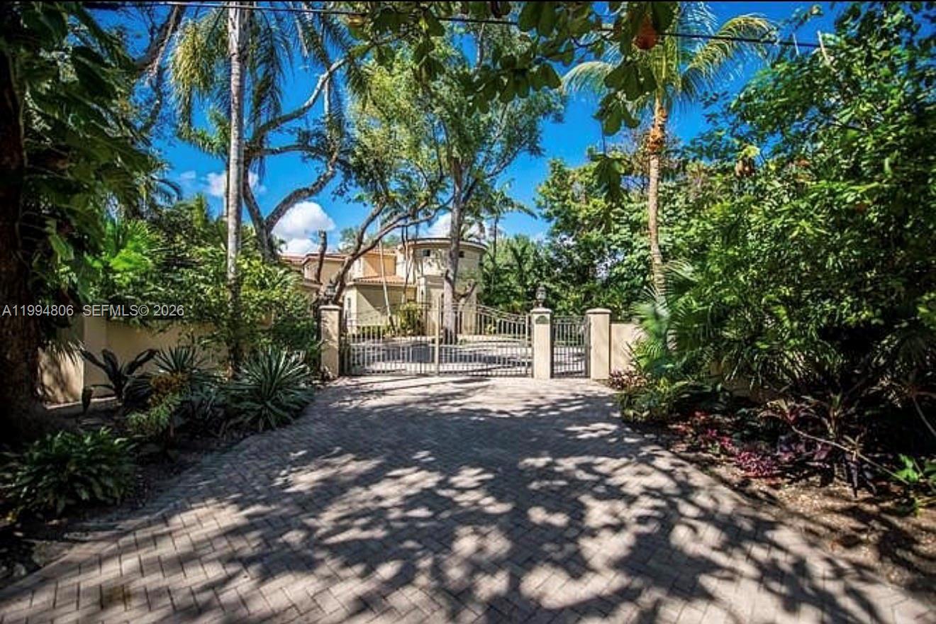A paved driveway leads to a gated entrance in front of a multi-story house — 3630 Justison Rd, Miami FL 33133, MIAMI, FL