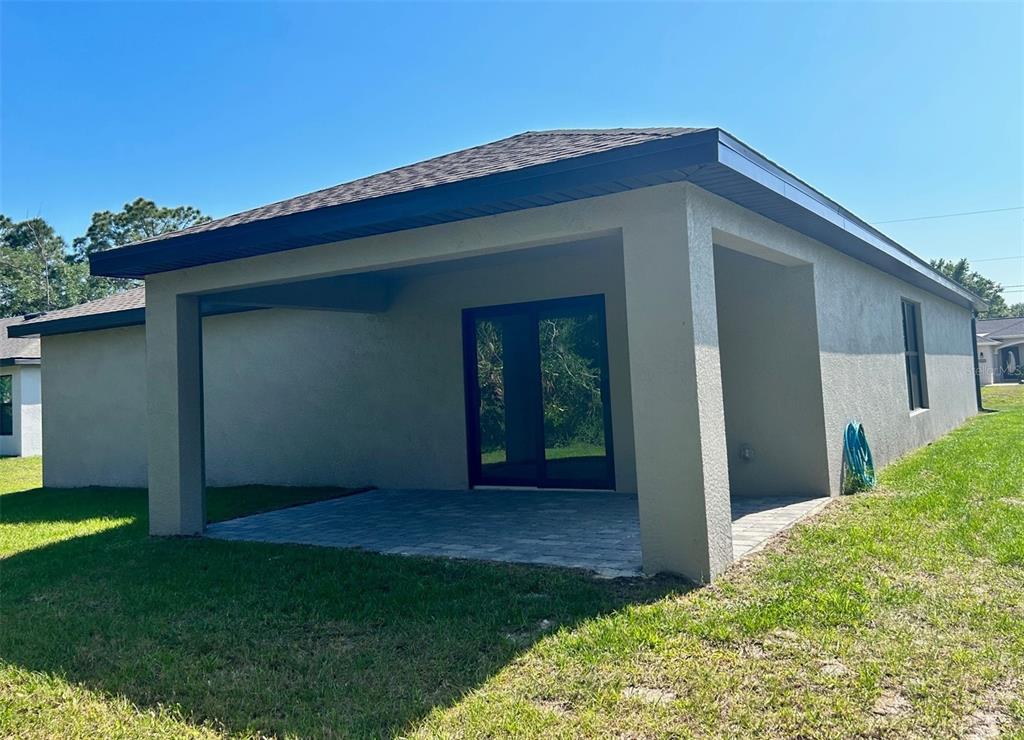A covered patio with a paver floor and sliding glass doors attached to a house — 7220 SWARTBURG ROAD, NORTH PORT, FL