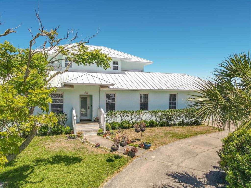 A two-story house with a white metal roof and light blue siding — 1205 S RIVERSIDE DRIVE, EDGEWATER, FL