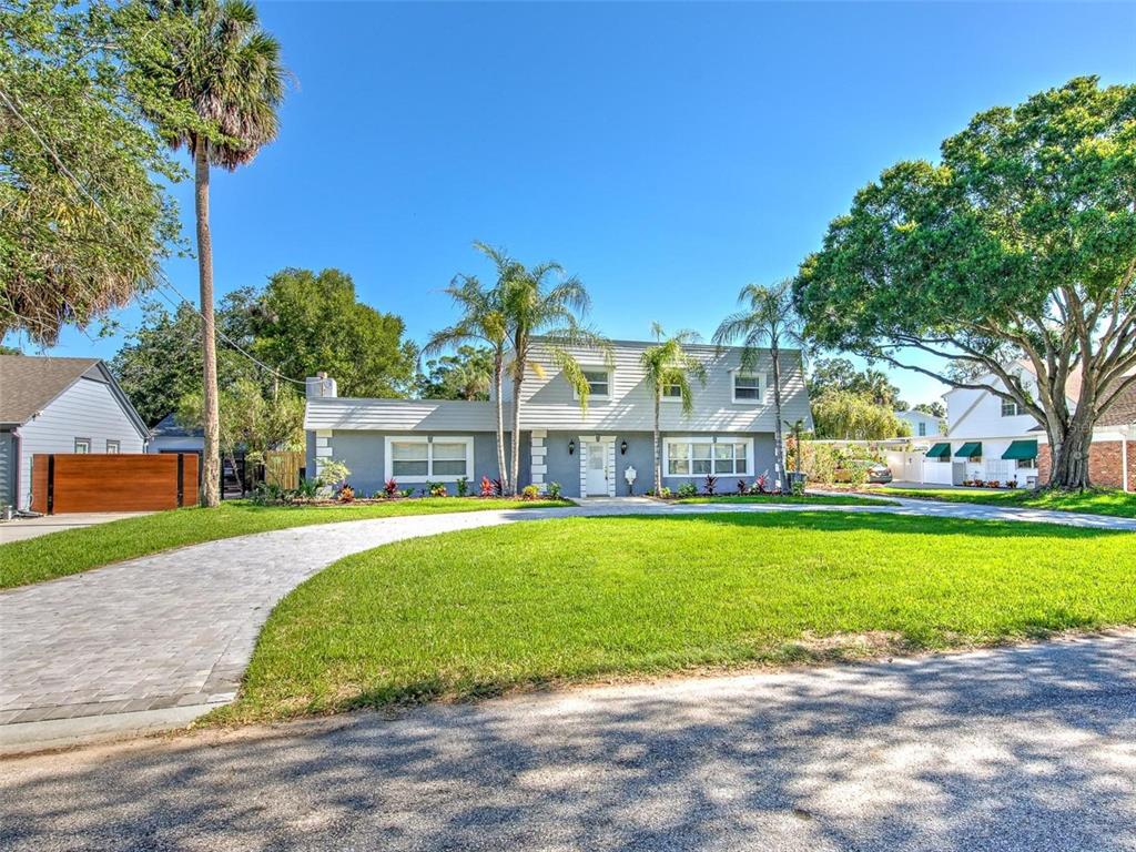 A two-story gray house with a paved driveway and palm trees in the front yard — 4711 W SAN RAFAEL STREET, TAMPA, FL