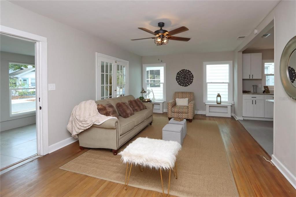 A living room features hardwood floors, a beige sofa, a patterned armchair, and a ceiling fan — 1532 13TH STREET S, ST PETERSBURG, FL
