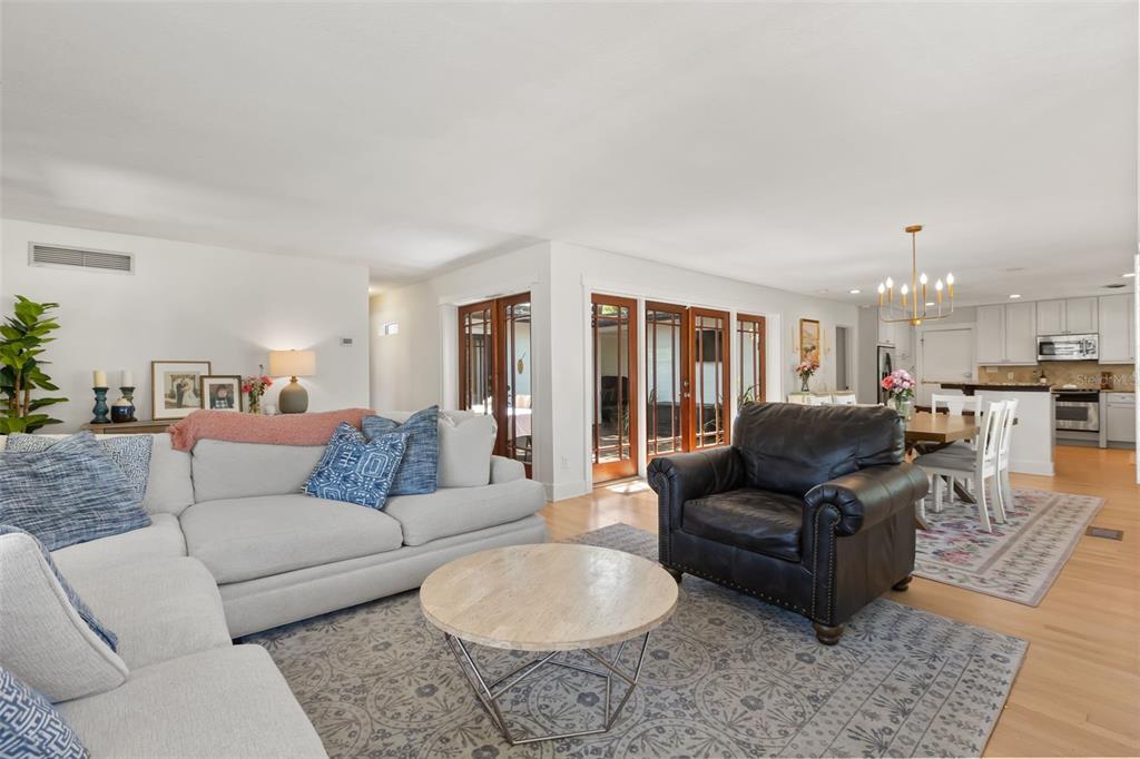 A living room with a sectional sofa, leather armchair, and French doors leading outside — 934 BOARDMAN STREET, ORLANDO, FL