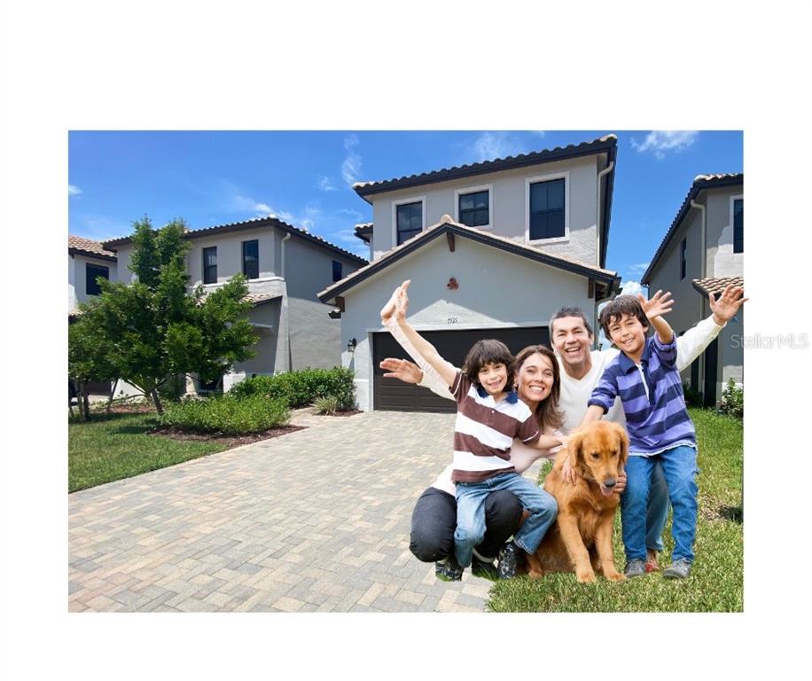 A family and their dog pose in front of a two-story suburban house — 5525 AGOSTINO WAY, AVE MARIA, FL