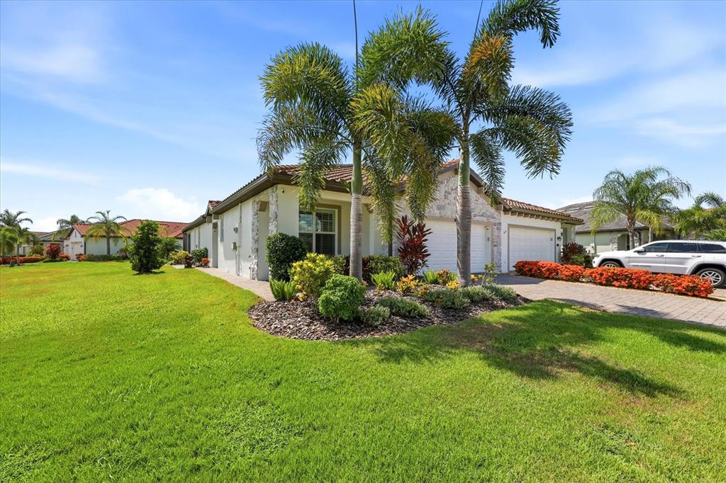 A single-story house with a tiled roof, palm trees, and a paved driveway — 2405 WILDFLOWER RUN, LAKEWOOD RANCH, FL
